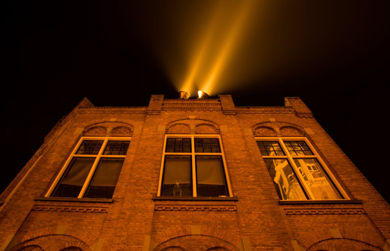 The Art of Drawing Readers In: Your attractive post title goes here A night shot of a historical brick building with light beams in Groningen, Netherlands.